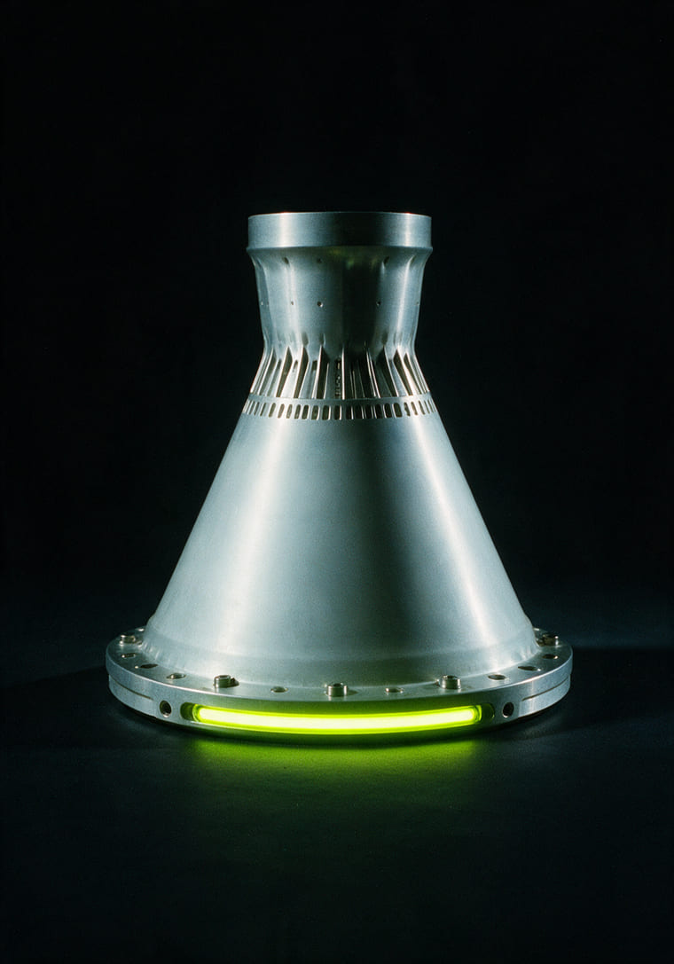 A machined engine nozzle bell in white metal, on black